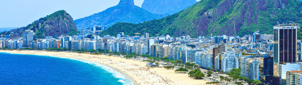 Copacabana: a praia mais estratégica do Rio para aluguel por temporada Vista aérea da Praia de Copacabana, com orla movimentada, prédios residenciais e o mar azul do Rio de Janeiro, destacando localização estratégica e alta demanda turística durante todo o ano.
