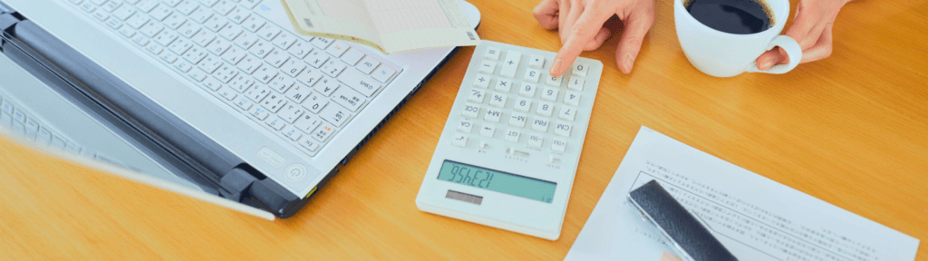 Pessoa analisando números com calculadora e notebook, simbolizando decisões estratégicas baseadas em dados na gestão de imóveis por temporada.