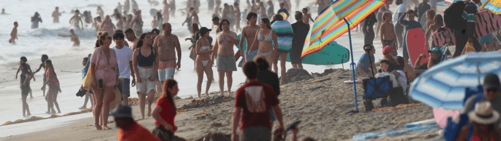 Praia cheia na alta temporada no Rio de Janeiro, ilustrando o aumento de demanda e a pressão operacional no aluguel por temporada.