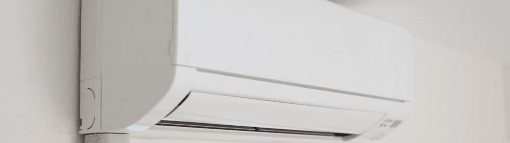 Ar-condicionado inverter instalado em parede interna de apartamento para aluguel por temporada, destacando eficiência energética