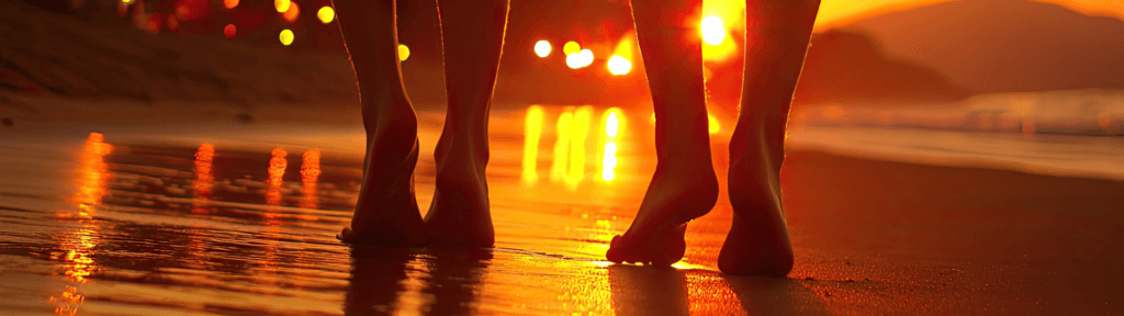Casal caminhando na praia ao pôr do sol no Rio de Janeiro, representando o perfil mais tranquilo do turista durante o outono.