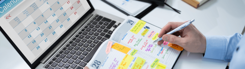 Pessoa organizando calendário e planejamento em notebook, simbolizando precificação dinâmica e gestão ativa no aluguel por temporada.