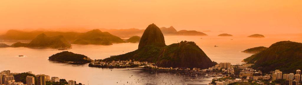 Vista aérea do Rio de Janeiro ao entardecer com tons dourados, representando a transição de estação e a maturidade na gestão do aluguel por temporada.