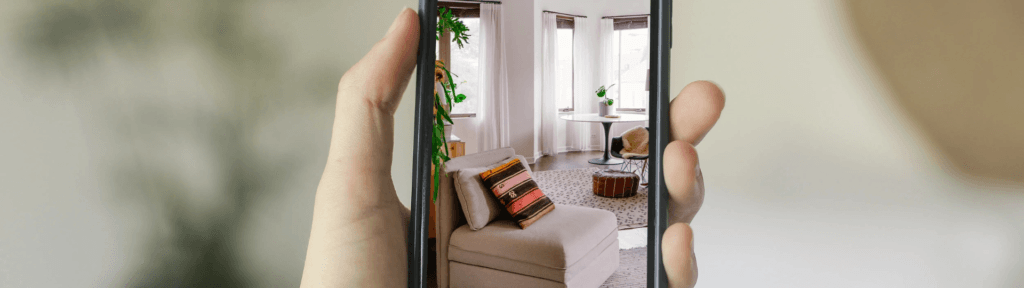 Pessoa segurando celular com foto de apartamento representando otimização e atualização de anúncio no Airbnb