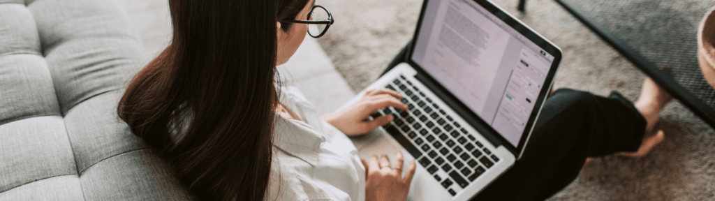 Pessoa trabalhando no notebook em ambiente confortável representando trabalho remoto e novas demandas no Airbnb na baixa temporada